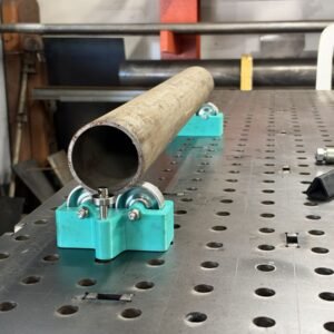 Pipe resting on a JOMAC magnetic tubing roller on a perforated welding table