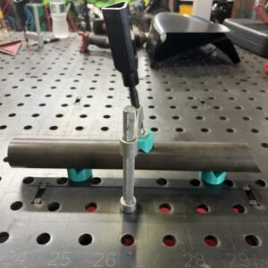 Three JOMAC magnetic V-blocks holding a round tube on a fixture table, one attached to the end of a clamp